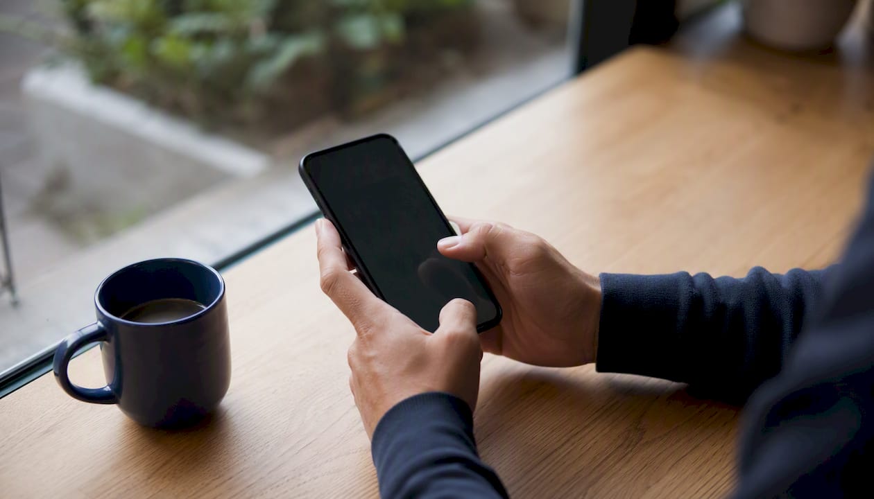 Persona utilizando el móvil para gestionar ventas a través de WhatsApp