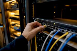 Mano conectando un cable de troncal SIP en la sala de servidores