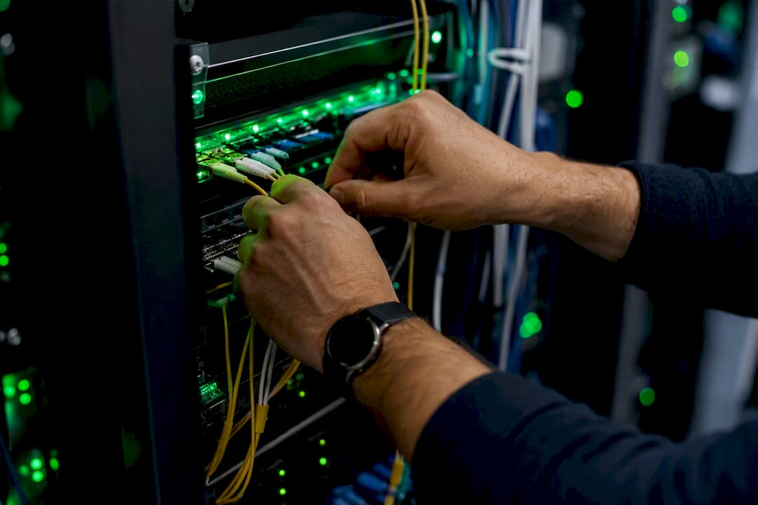 Manos trabajando con cables de una red de telecomunicaciones