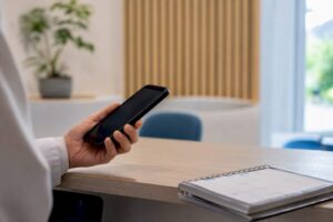 Persona sosteniendo el auricular del teléfono de la clínica