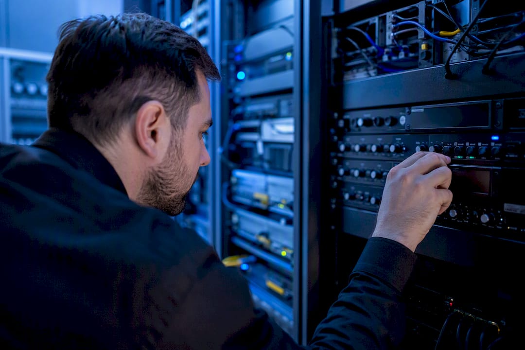 Mano ajustando diales del hardware de telecomunicaciones