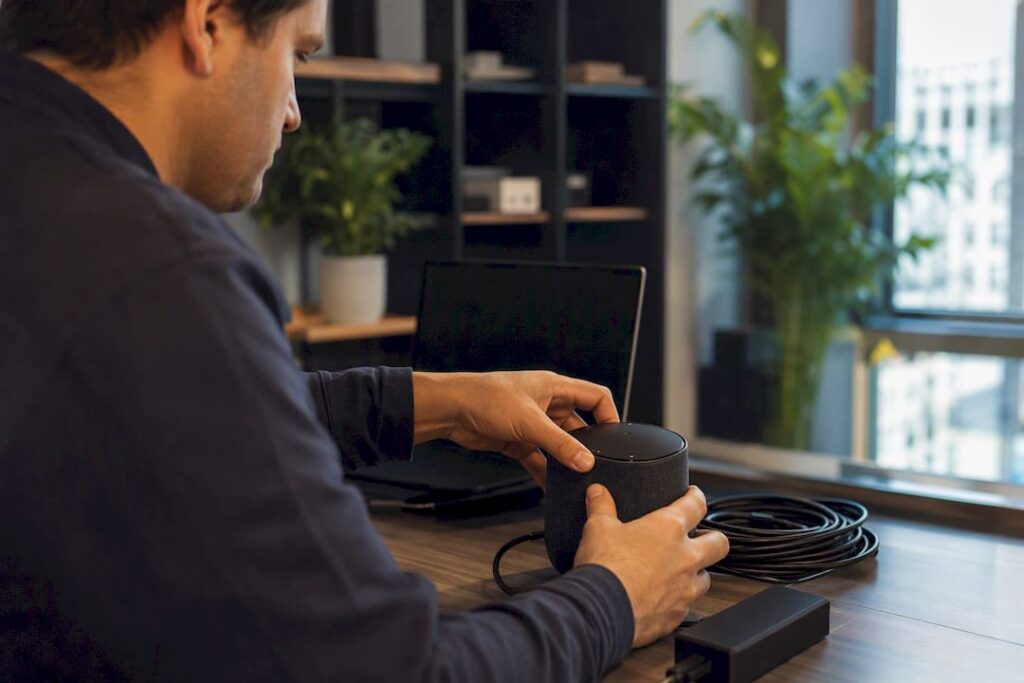 Manos conectando un dispositivo de asistente de voz con IA